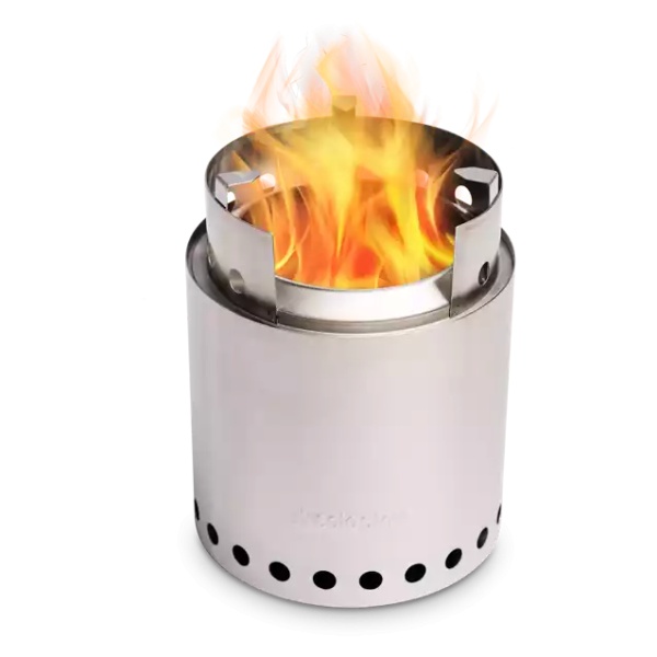 A portable stainless steel camp stove with flames on a black background.