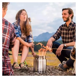 A group of individuals gathering around a portable solo stove stainless steel campfire.