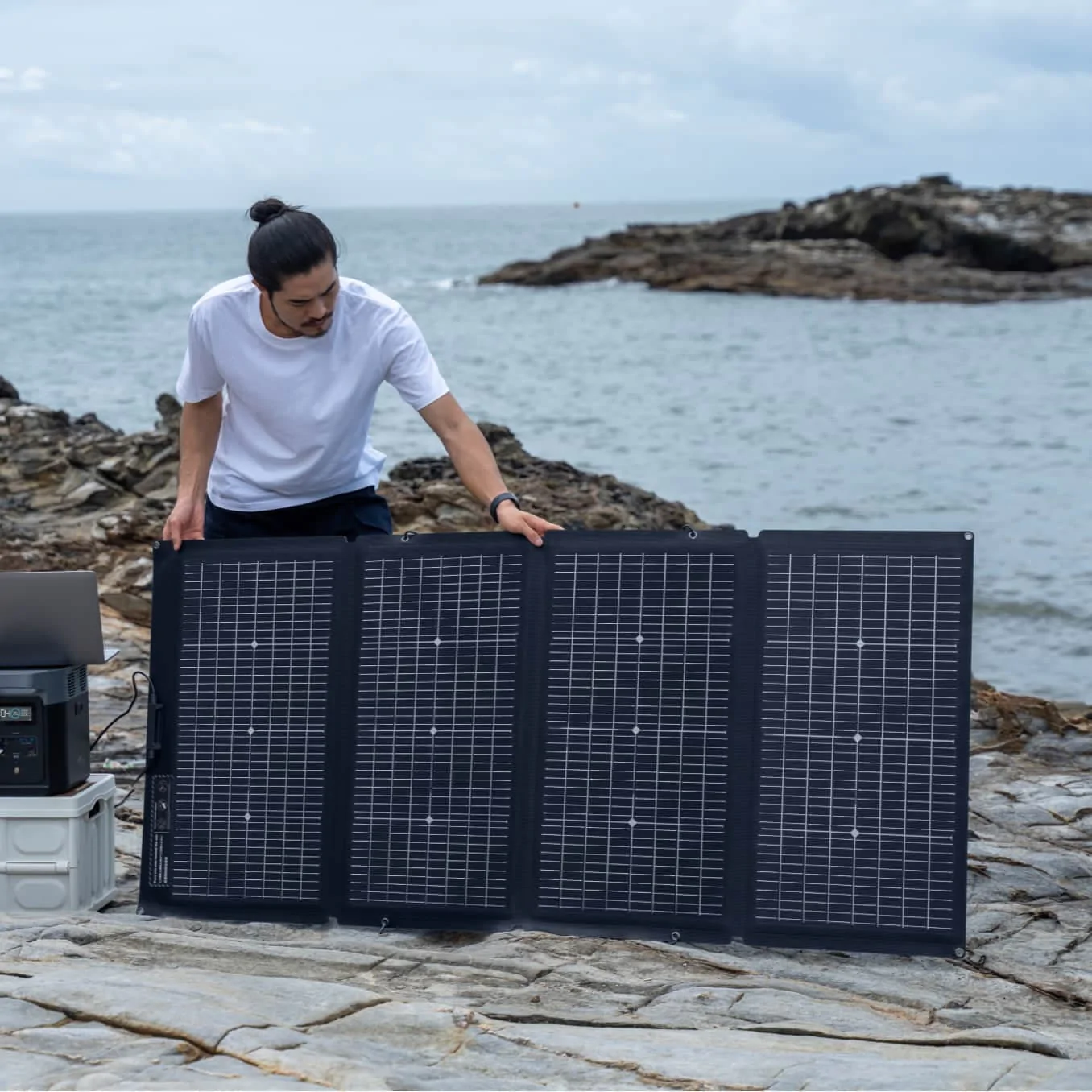A man showcasing EcoFlow's portable solar panel at the beach.