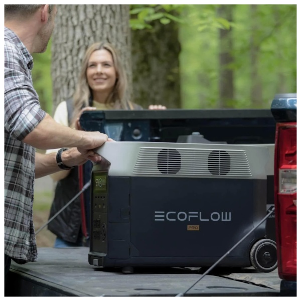 A man and woman are installing an EcoFlow DELTA Pro Portable Power Station in the back of a pickup truck.