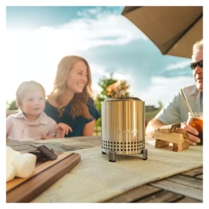 A family enjoys the warmth of a Solo Stove Mesa Tabletop Stainless Steel Fire Pit at their outdoor table.
