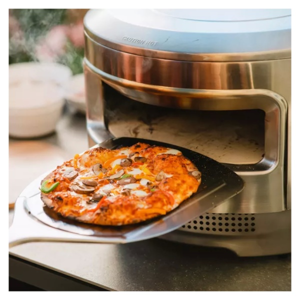 A portable and "smokeless" pizza oven cooks a pizza.