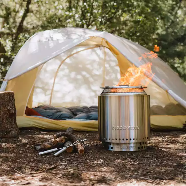 A portable stainless steel camp stove bundled with a tent, suitable for backyards and designed to be smokeless.