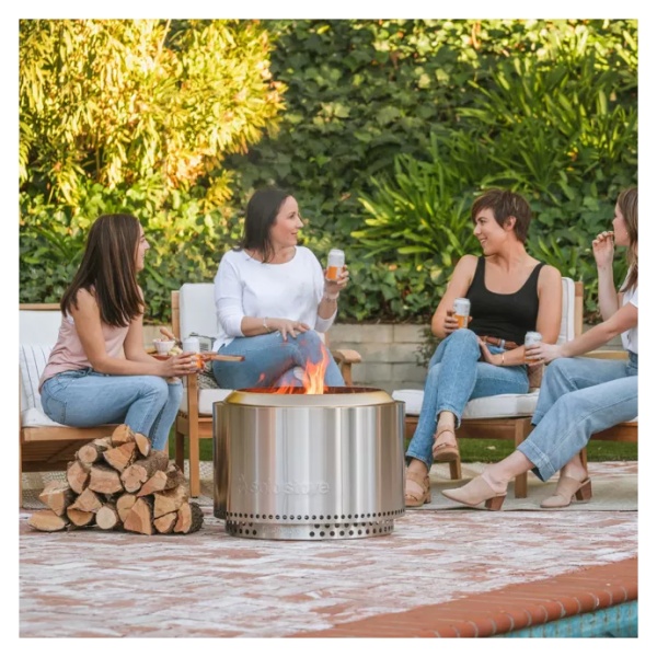 A group of women sitting around a "smokeless" fire pit.