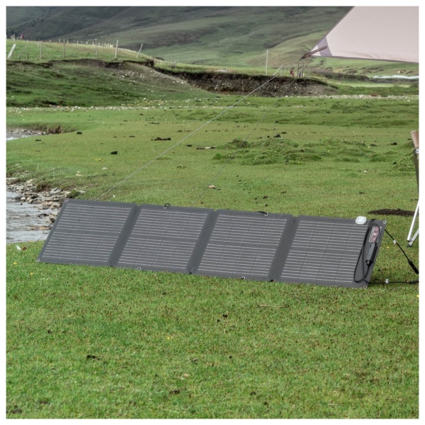 The EcoFlow 110W Portable Solar Panel is set up in the grass next to a tent.