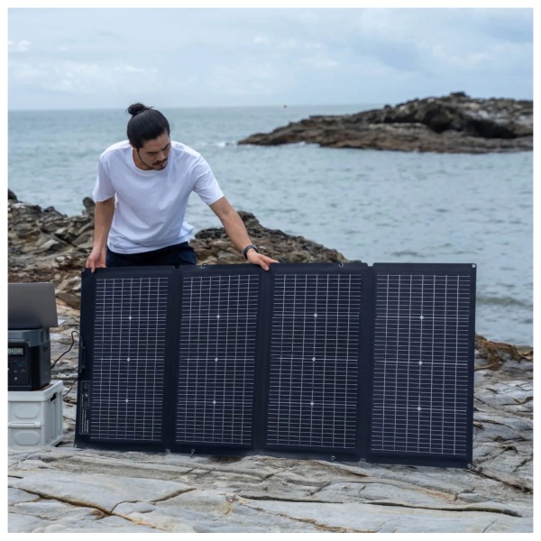 A man on the beach with an EcoFlow 220W Front and 155W Rear Bifacial Portable Solar Panel.
