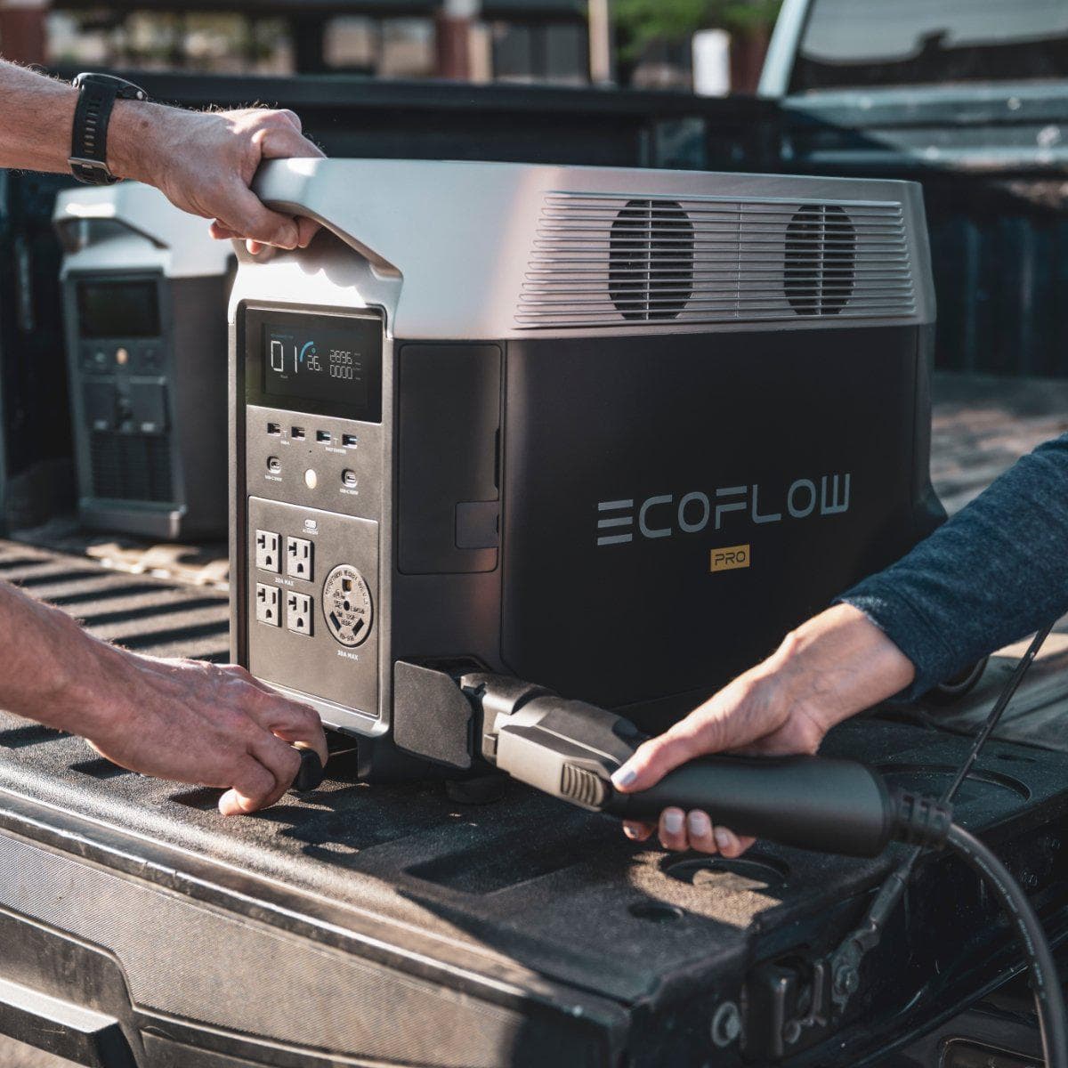 A man is installing an EcoFlow DELTA Pro electric generator in the back of a pickup truck.