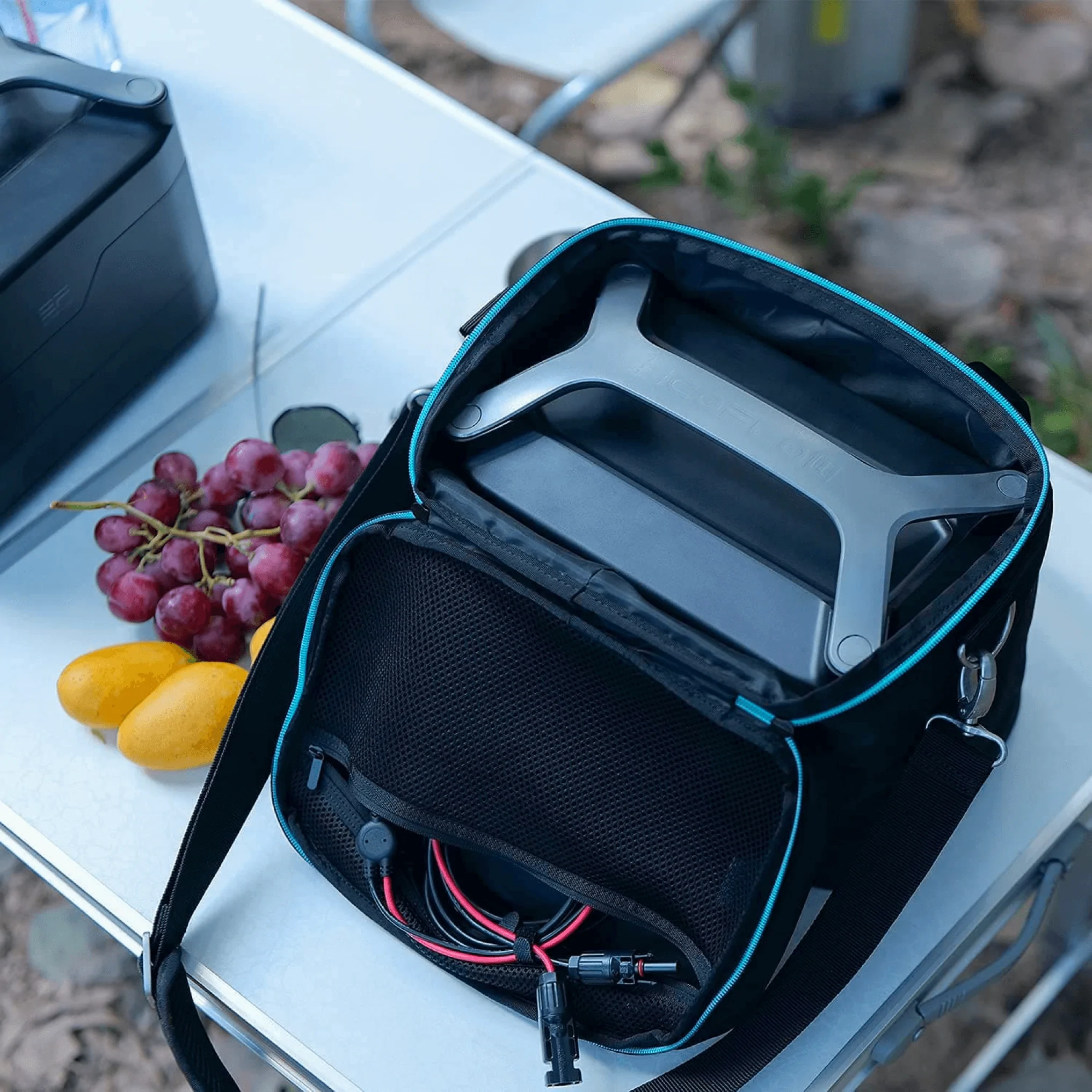 A laptop and an EcoFlow RIVER Bag on a picnic table.