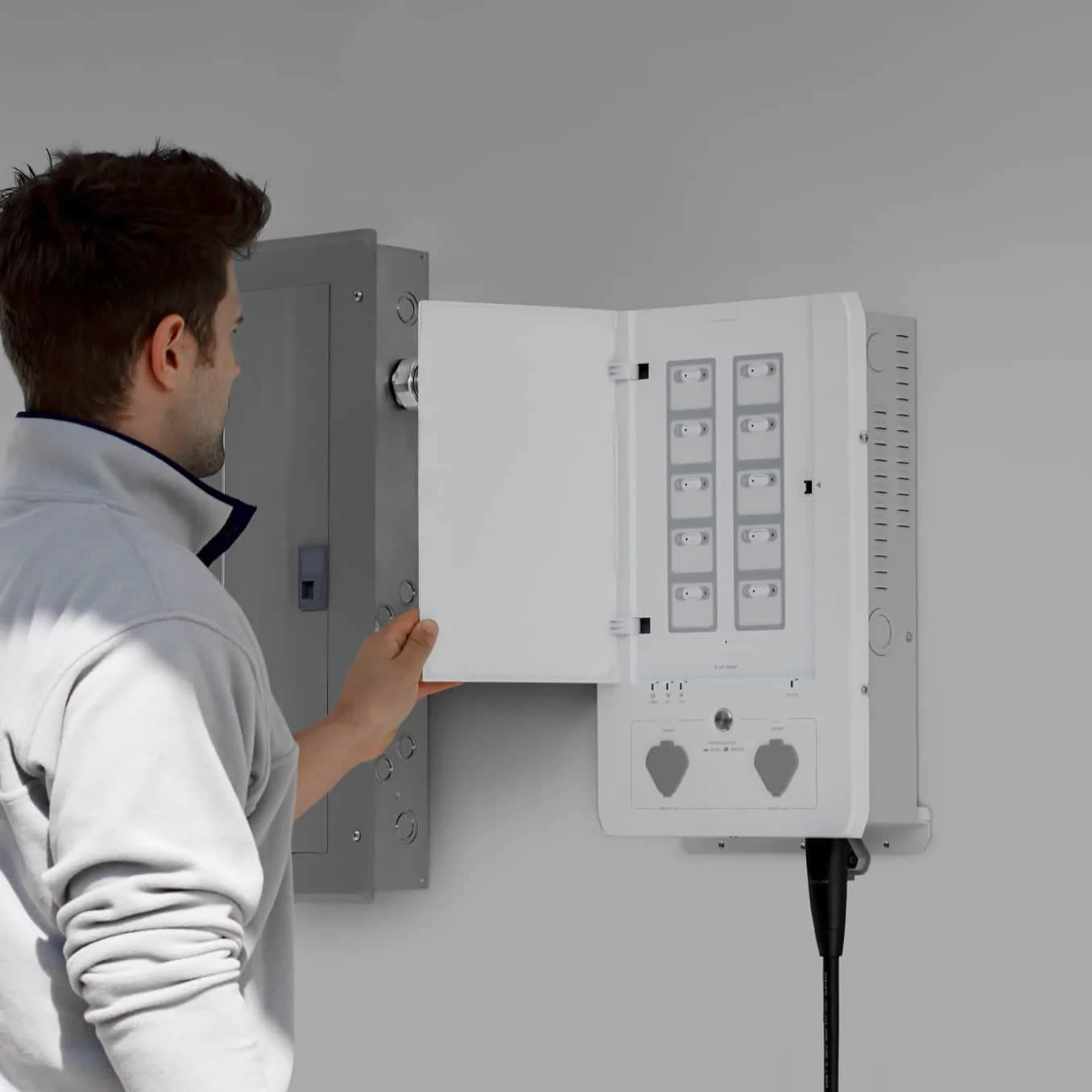 A man is installing an electrical box with the EcoFlow Smart Home Panel.