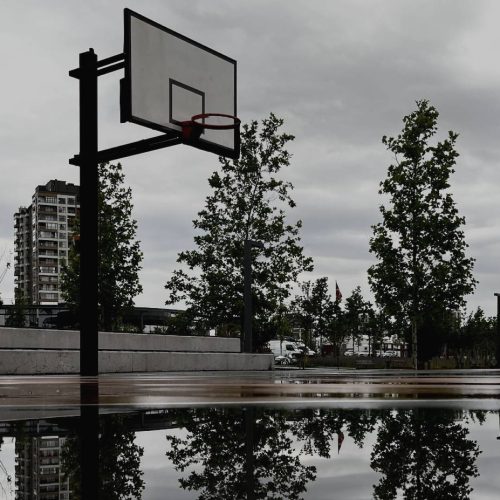 A puddle reflecting a basketball hoop.