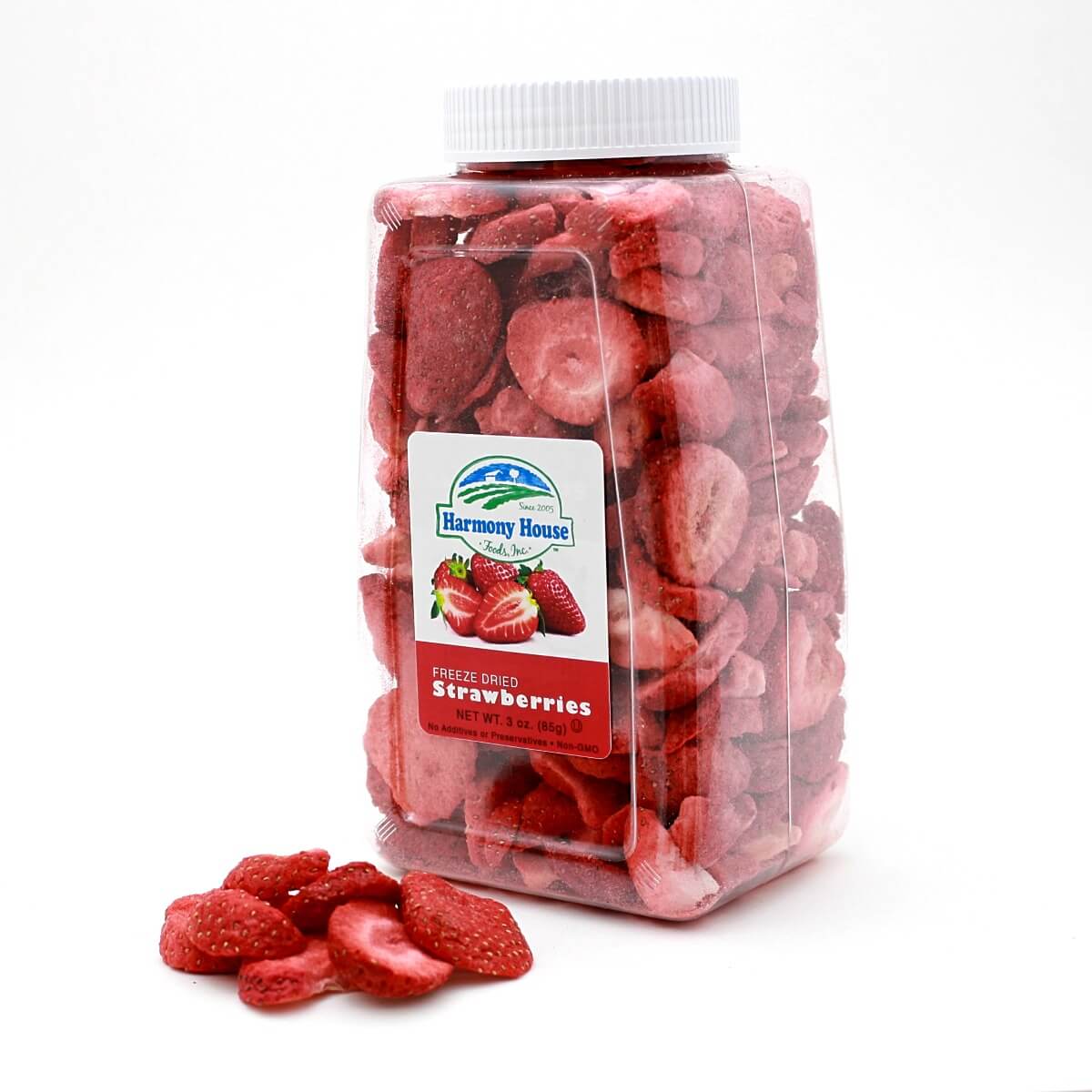 A jar of sliced Harmony House Freeze Dried Strawberries (3 oz) sitting on a white surface.