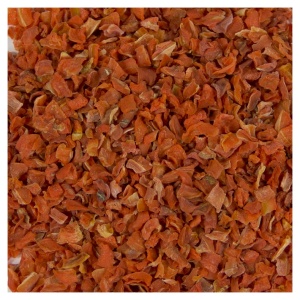 A pile of dried red peppers on a white surface.