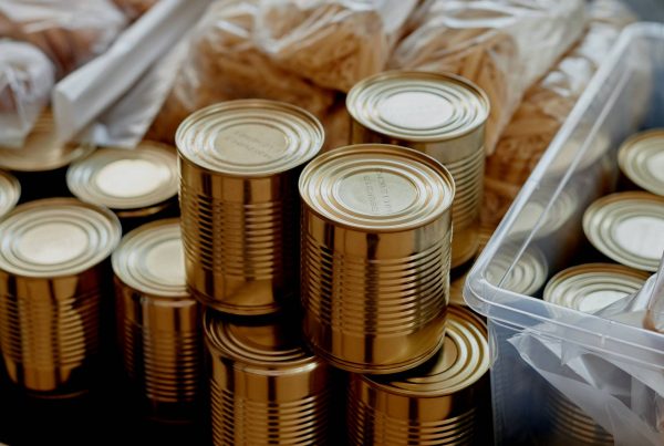 A group of cans on a table, part of building a 1-year food and water storage for your family.