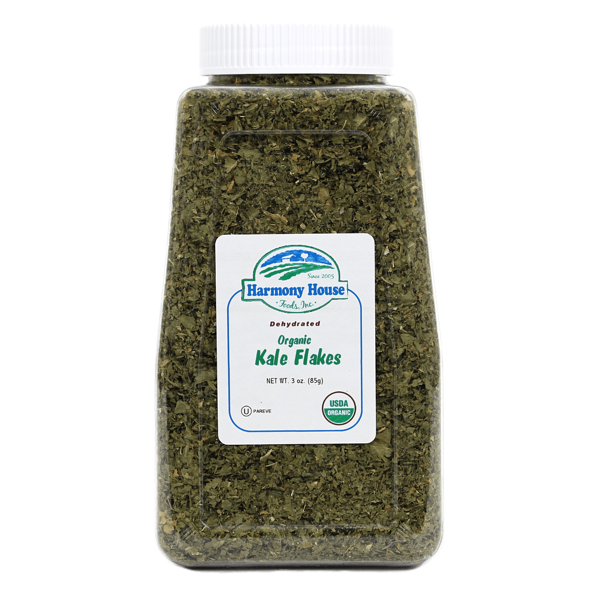 A jar of kale pesto with Harmony House Organic Dried Kale Flakes on a white background.