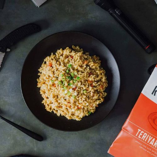 A comprehensive guide on survival food storage featuring a bowl of fried rice and a bag of matches on a table.