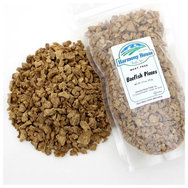 A bag of granola next to a bag of Harmony House Beef Style Pieces (Unflavored) (2.5 oz) - SHIPS IN 1-2 WEEKS.