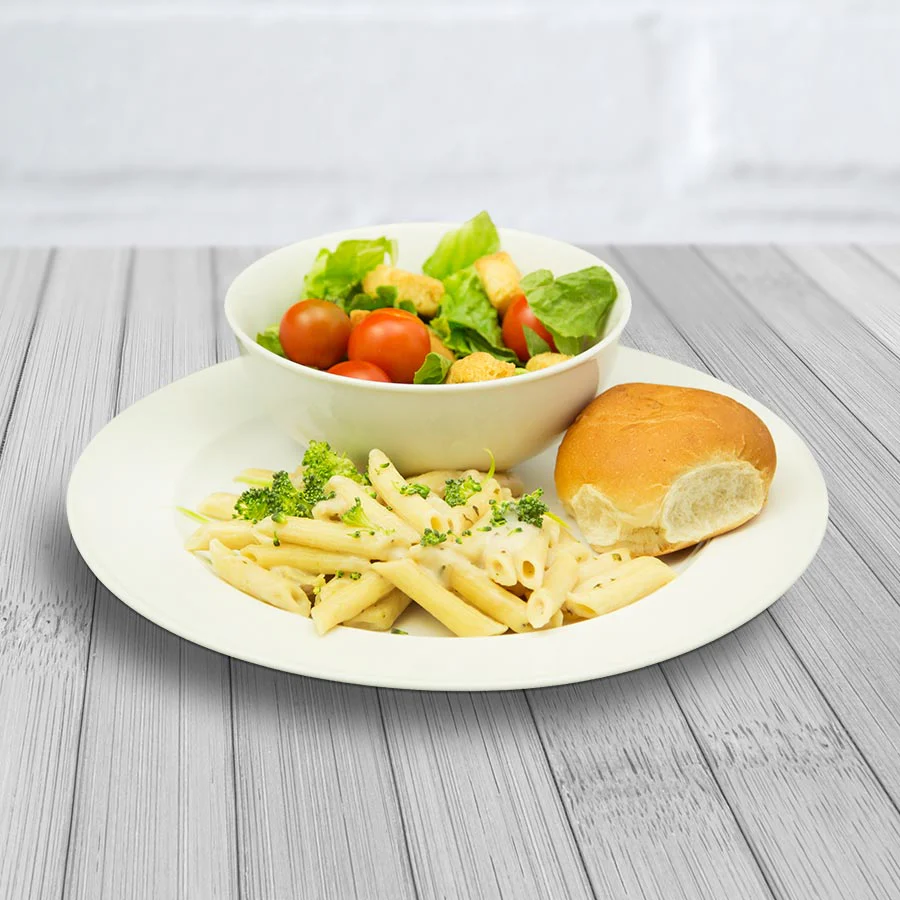 A white plate with a bowl of pasta and salad for emergency food storage.