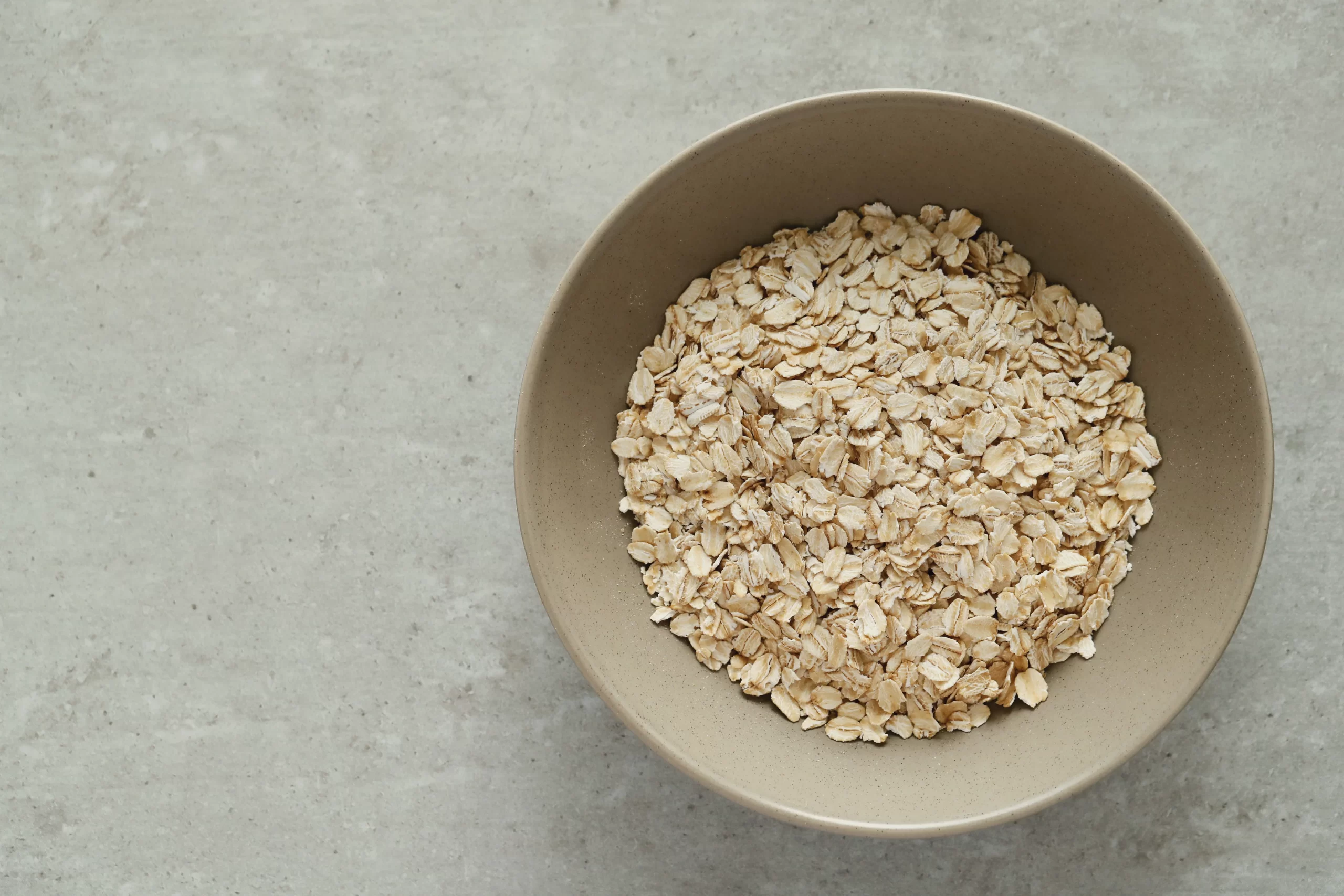 Emergency food storage is important, especially when considering the unpredictable nature of supply chains. Oats in a bowl on a concrete surface are a practical option to have for long-term sustenance.