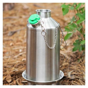 A stainless steel water bottle, used for emergency food storage, sitting in the woods.