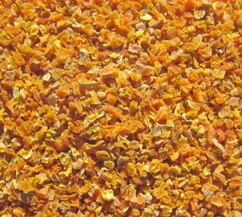 A pile of dried oranges with a red background.