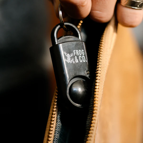 A person holding a key ring from Frog & Co. in their pocket.