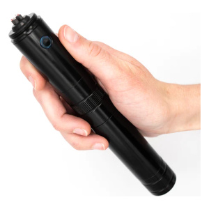 A person's hand holding a small black device called the Tesla Knife Arc Lighter, developed by Frog & Co.