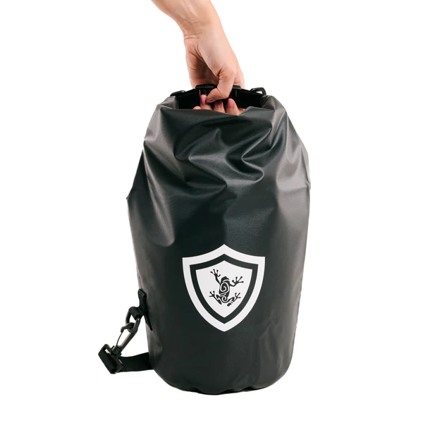 A person holding a black dry bag with a Frog & Co shield on it.