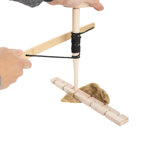 A person is holding a frog wooden stick with a rope attached to it.
