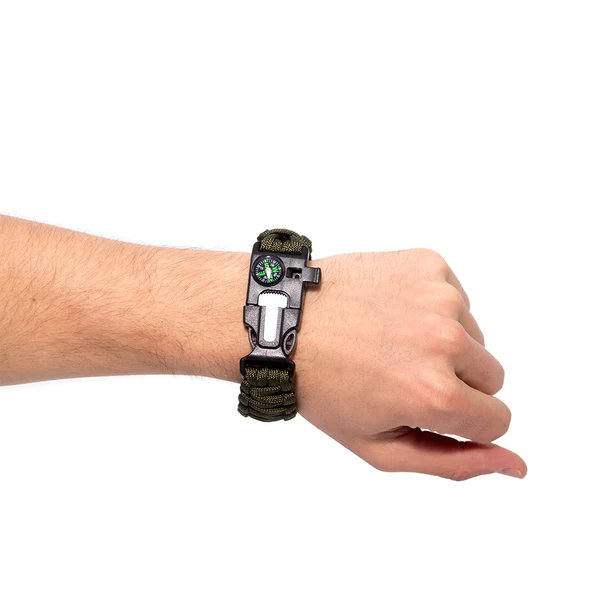 A man's hand holding a Paracord Survival Bracelet with a compass on it, available from Frog & Co.