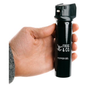 A hand holding a black pepper spray from Frog & Co., part of the LifeShield Self Defense Kit.