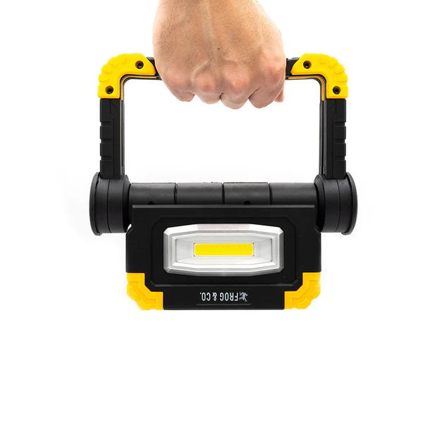 A Frog & Co hand holding a Portable LED Worklight.