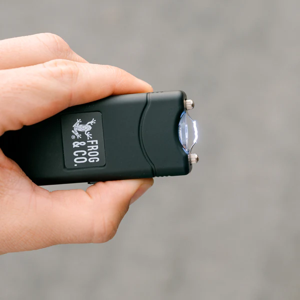 A person's hand showcasing a small flashlight from Frog & Co.'s Self Defense Kit.