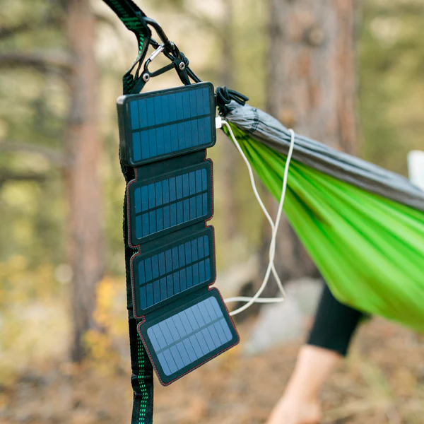 A person sitting in a hammock with a Solar Power Bank attached to it.